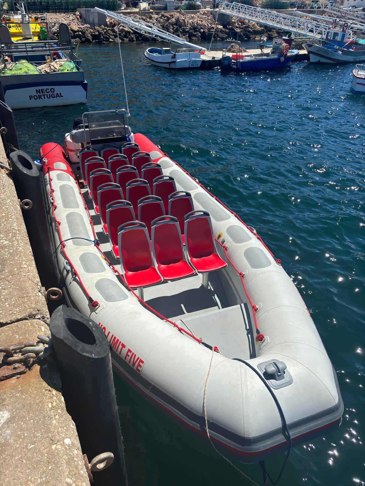 Inflatable boat with red seats docked at a harbor.
